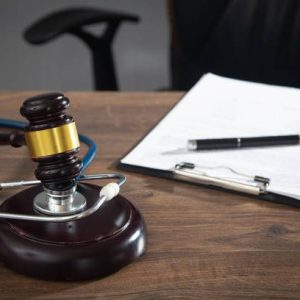 Judge gavel, documents and stethoscope on the wooden table. Judge gavel, documents and stethoscope on the wooden table.